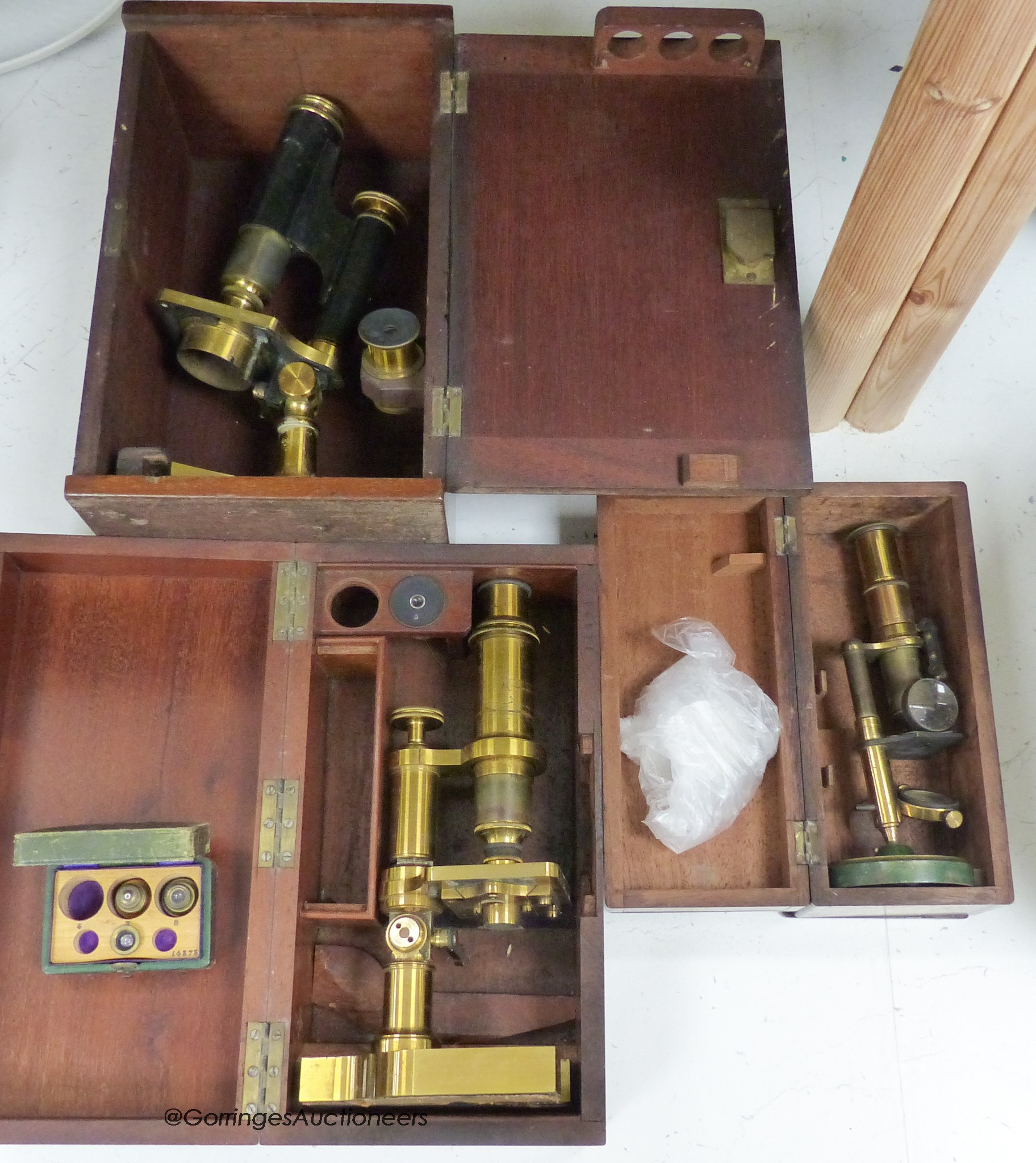 Three mahogany cased travelling microscopes and cased lenses